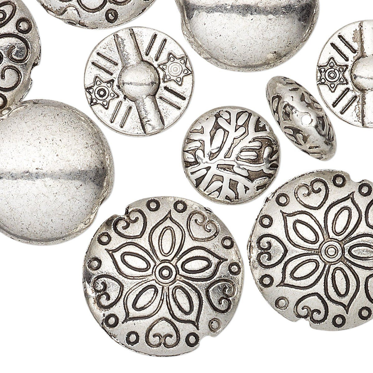 A close-up of multiple round silver-toned beads with embossed floral and geometric patterns on a plain white background.