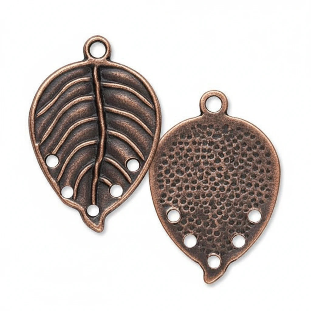 Two antique bronze leaf-shaped metal charms with hanging loops, one showing a raised leaf vein pattern and the other a textured honeycomb surface, on a plain white background.