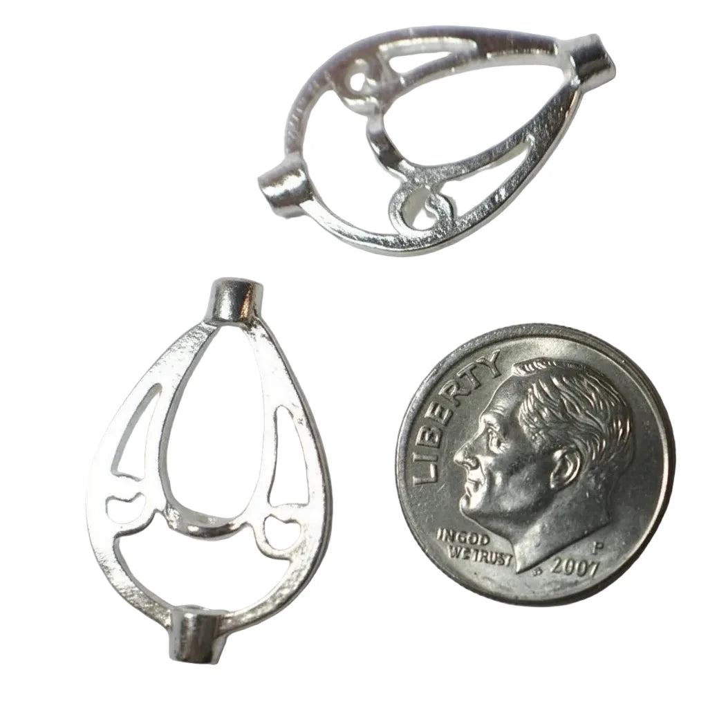 Two silver metal jewelry findings or charms shown on a plain light background, with a U.S.