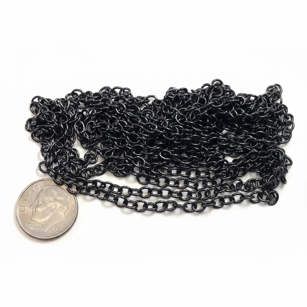 A coiled length of black metal chain links, shown next to a US quarter coin for scale, on a plain white background.