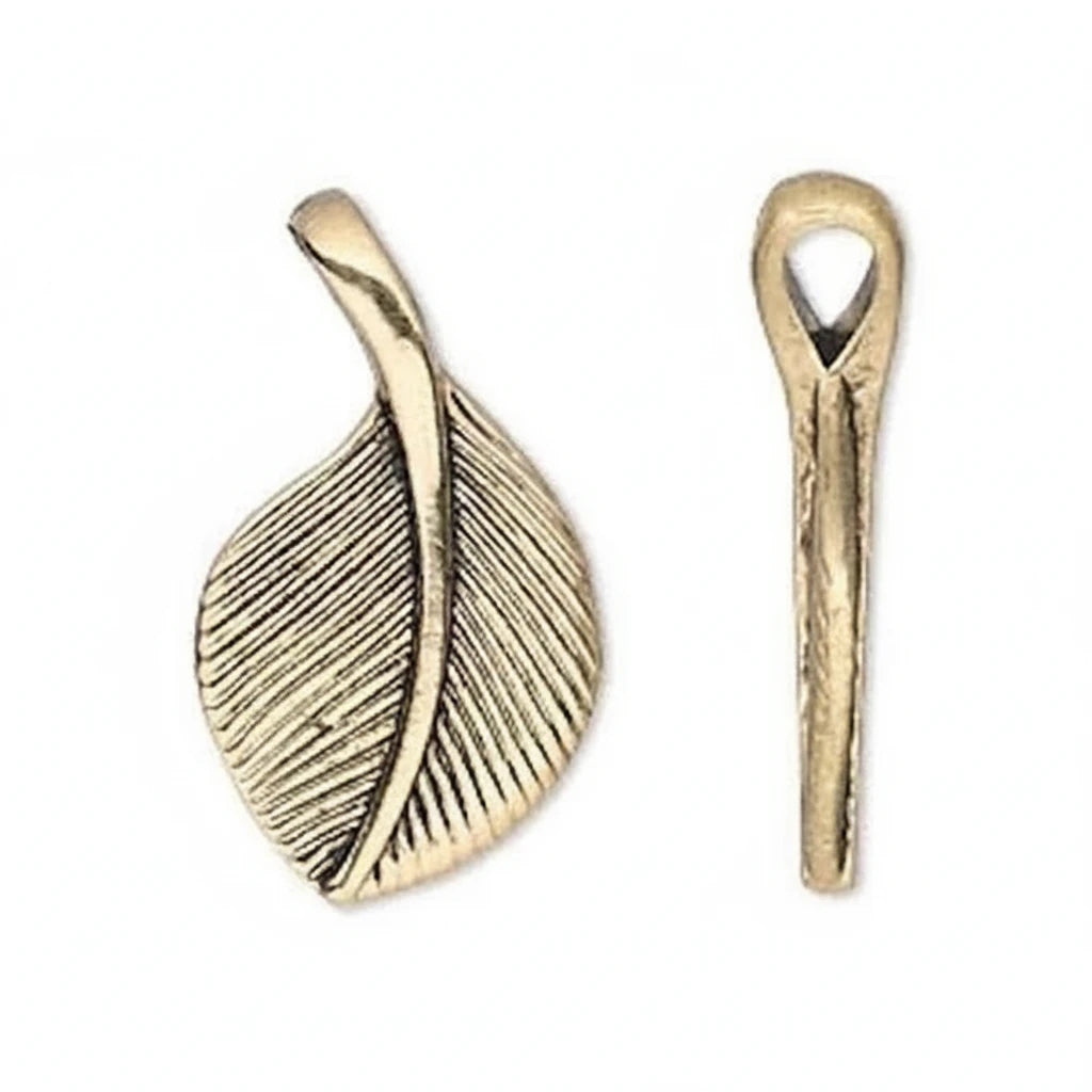 Two antique gold leaf-shaped jewelry findings on a plain white background, one showing the front textured face and the other showing the side profile with a loop at the top.