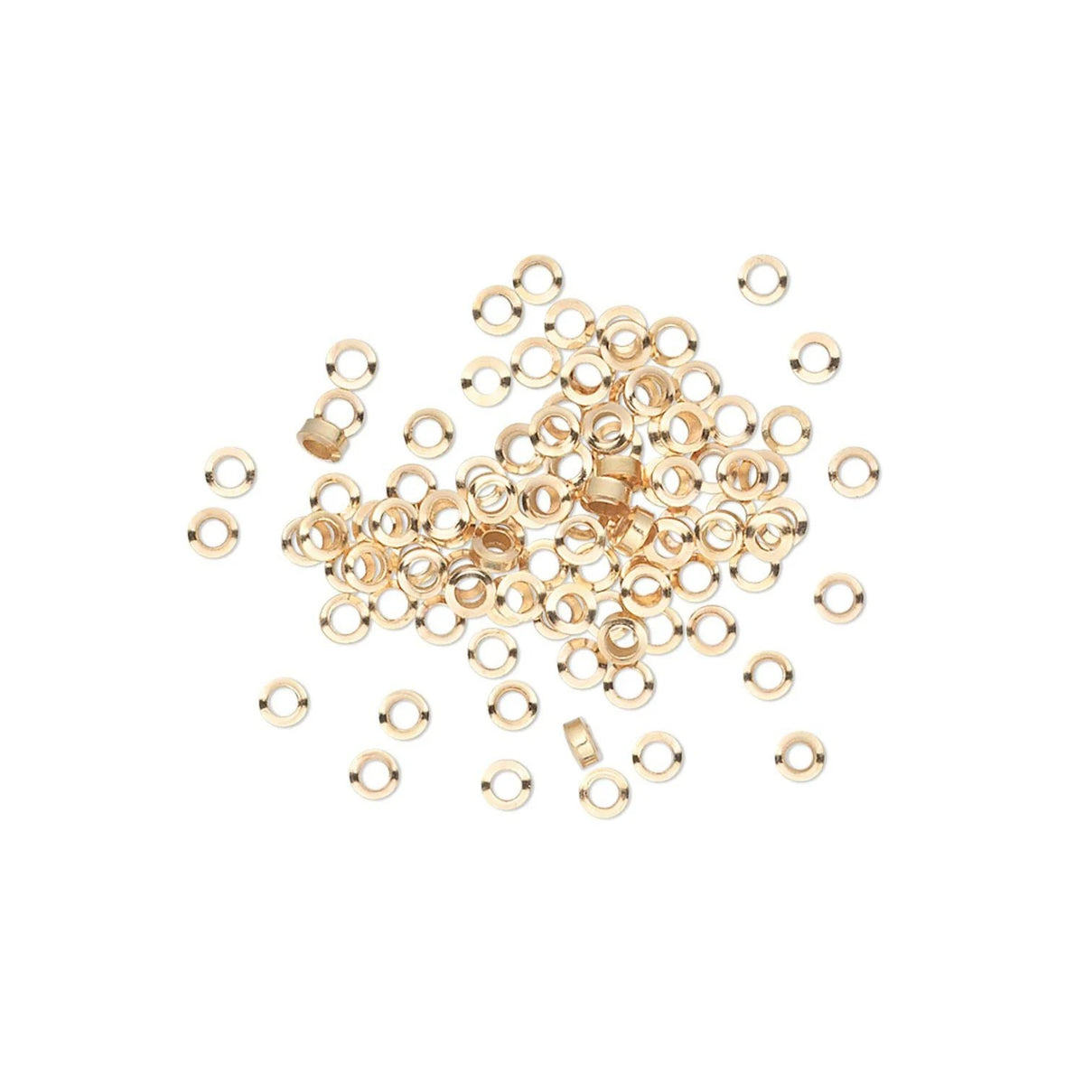 A pile of small metallic gold eyelets or rings scattered on a plain white background.