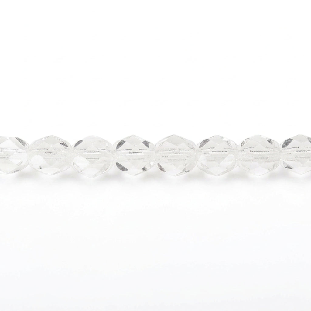 A close-up horizontal line of faceted clear glass beads on a plain white background.
