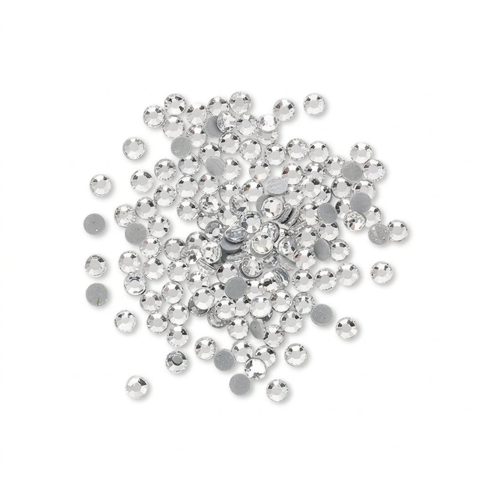 A pile of small round silver rhinestones with flat backs, scattered on a plain white background.