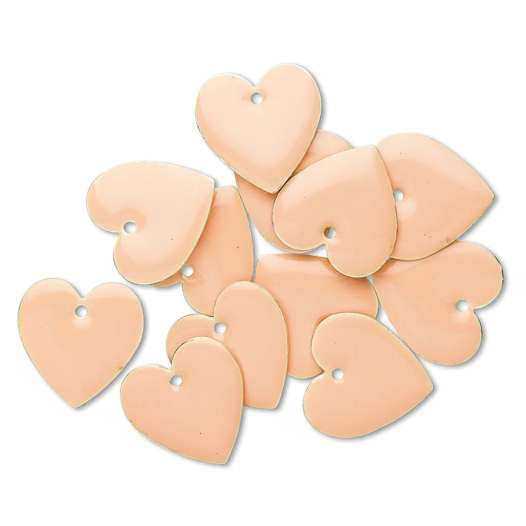 A pile of peach-colored heart-shaped beads with pre-drilled holes, arranged on a clean white background.