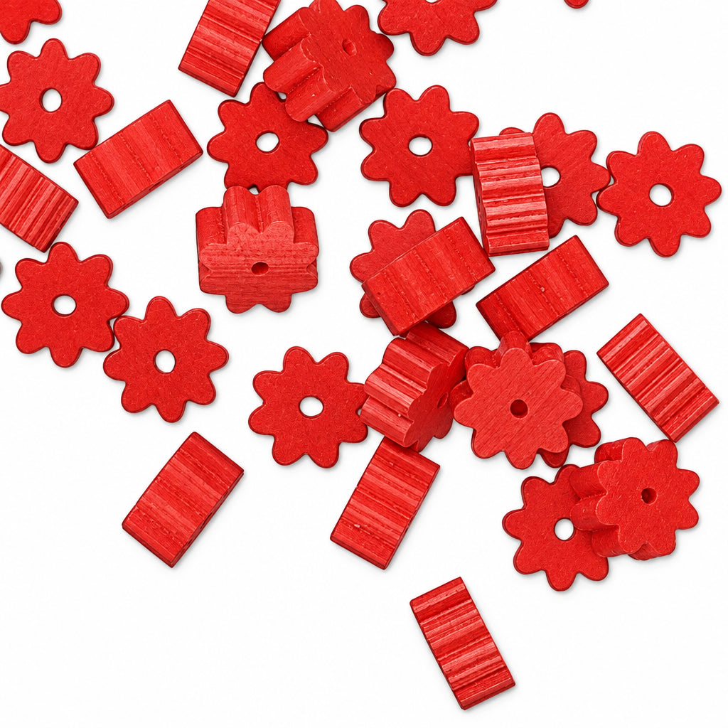 Red craft beads with floral and rectangular shapes scattered on a white background.