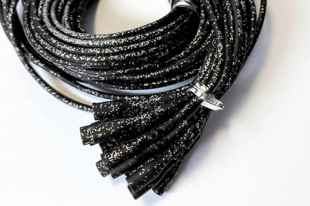 Black glittery cords with connectors on a white background
