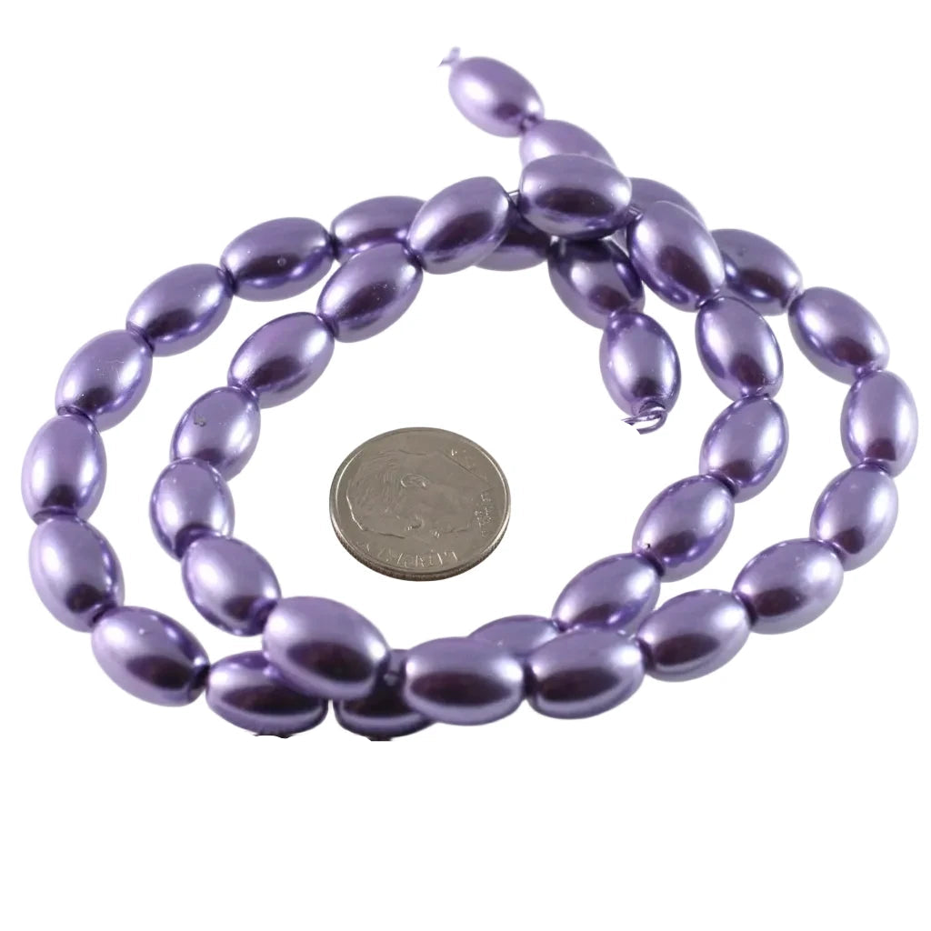 Purple metallic oval beads on a string, shown with a US quarter coin and a ruler for scale on a white background.