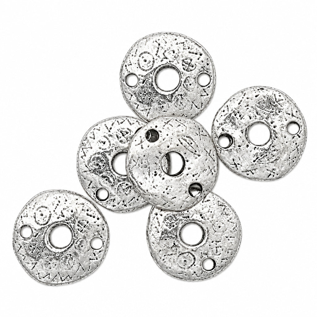 Five silver-toned round metal spacers with pre-drilled holes and a textured, antiqued finish, arranged on a plain white background.