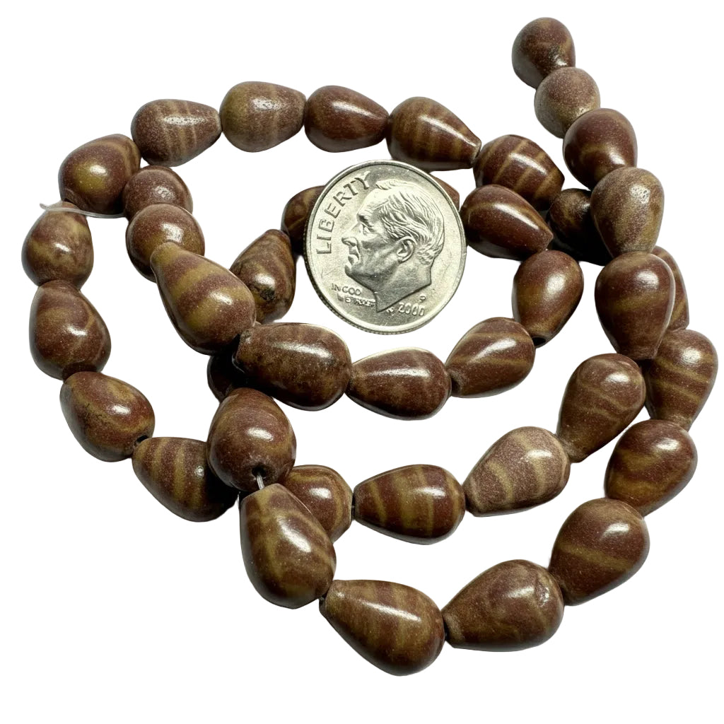 A strand of polished teardrop-shaped beads in brown and tan marbled stone, arranged in a circle around a silver dime for scale on a light gray background.