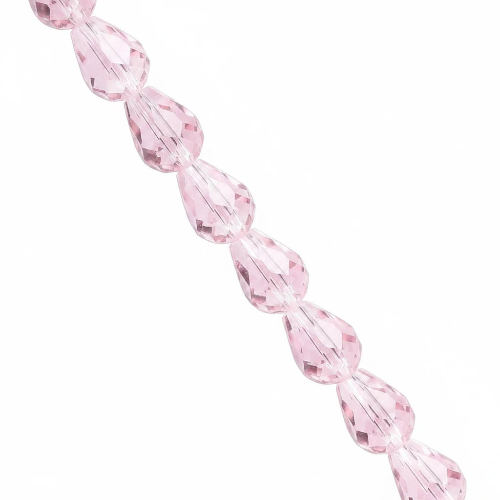 A strand of faceted light pink teardrop-shaped beads on a solid white background.