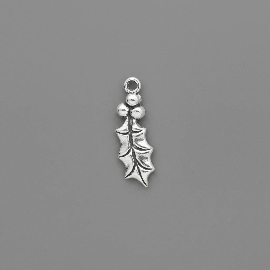 A small silver holly leaf charm with three berries and a top loop, shown on a solid dark gray background.
