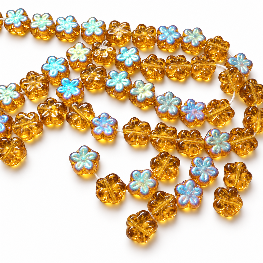 A strand of translucent amber glass beads shaped like four-leaf clovers, with some beads featuring iridescent pastel blue and white centers, displayed on a plain white surface.