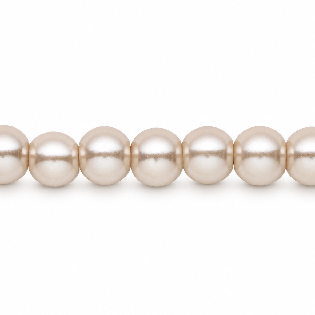 A close-up of a strand of round, lustrous pearl-like beads in a warm off-white or cream tone, shown against a plain white background.