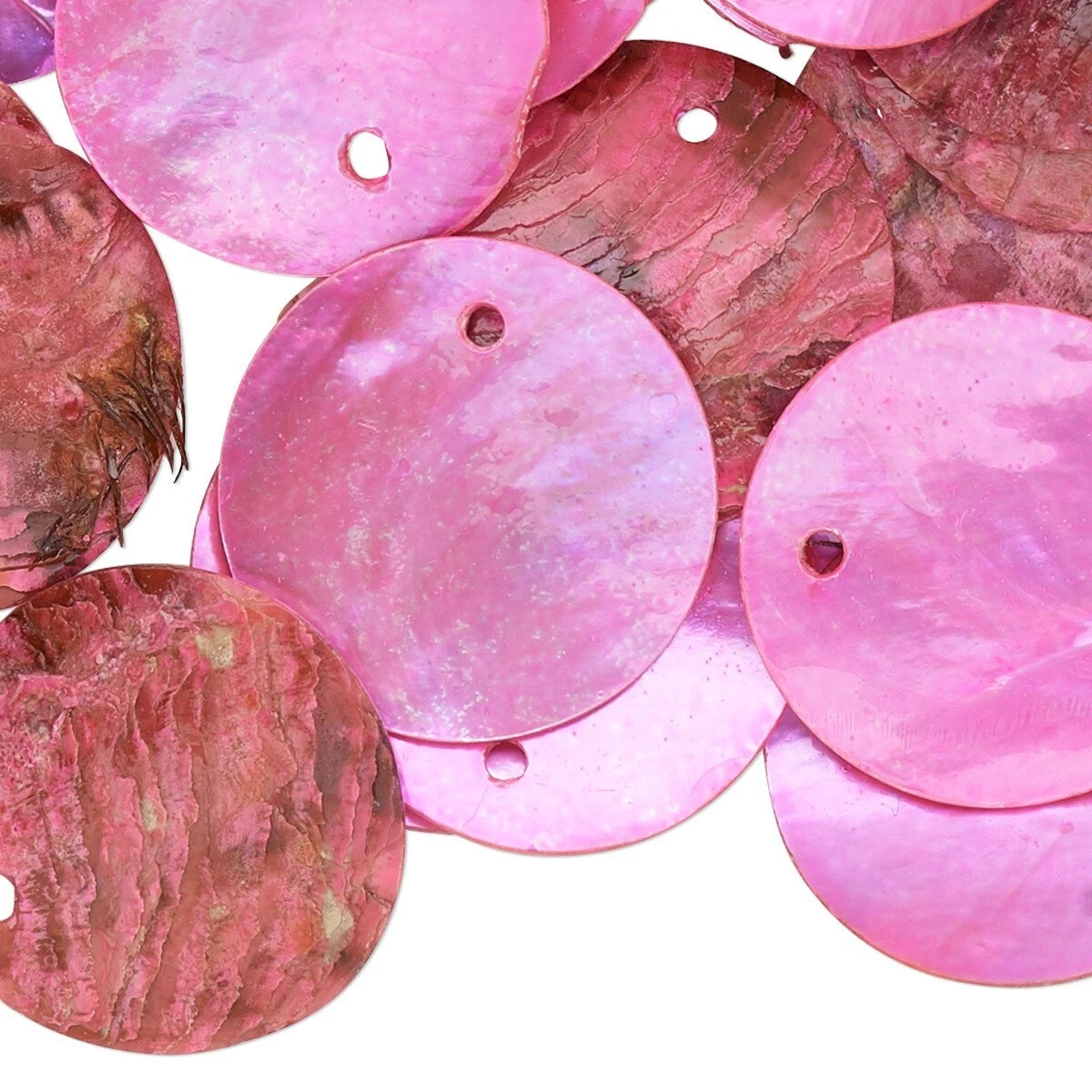 A pile of round pink shell sequins with small holes, showing a natural iridescent texture on a white background.