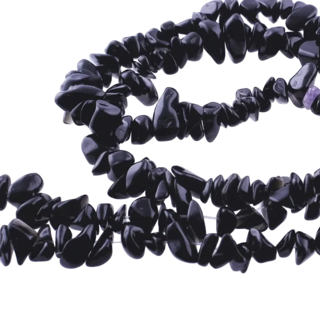 A strand of polished black tumbled stone chips, likely onyx or obsidian, coiled on a white background.