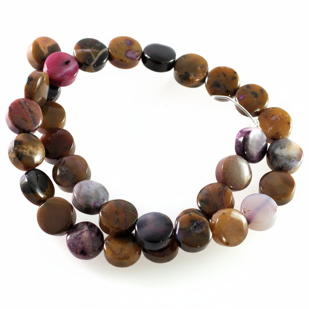 A strand of polished round gemstone beads in earthy brown, black, purple, and pink tones, arranged in a circle on a white background.