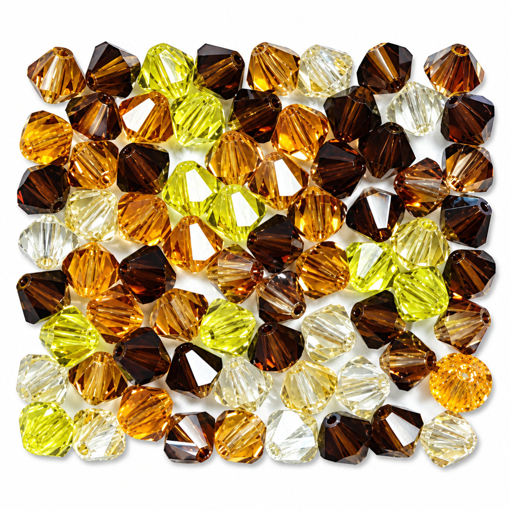 A pile of faceted glass beads in assorted colors including amber, brown, yellow, and clear, arranged on a white background.