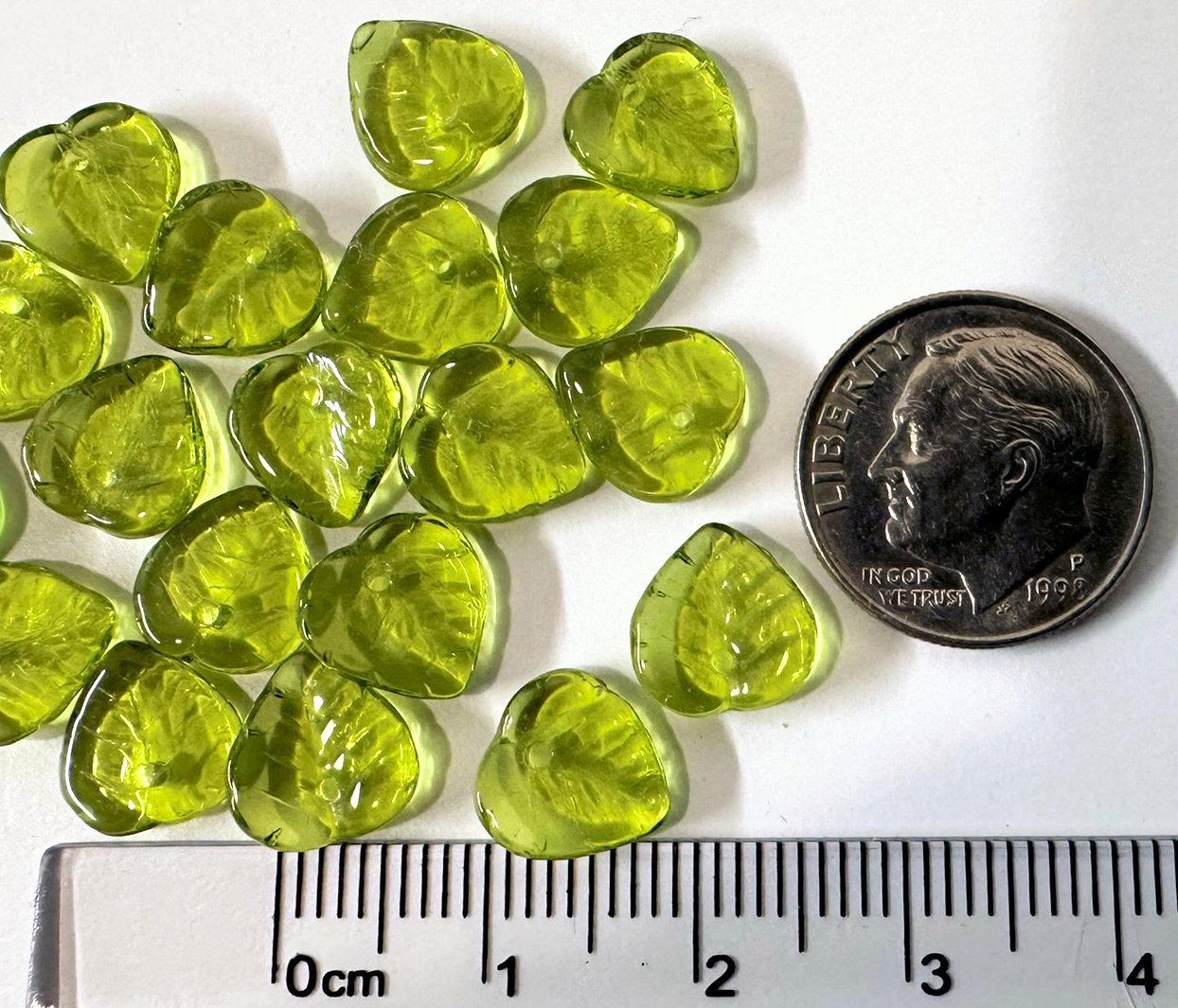 Green teardrop-shaped next to a dime for size comparison on a white background