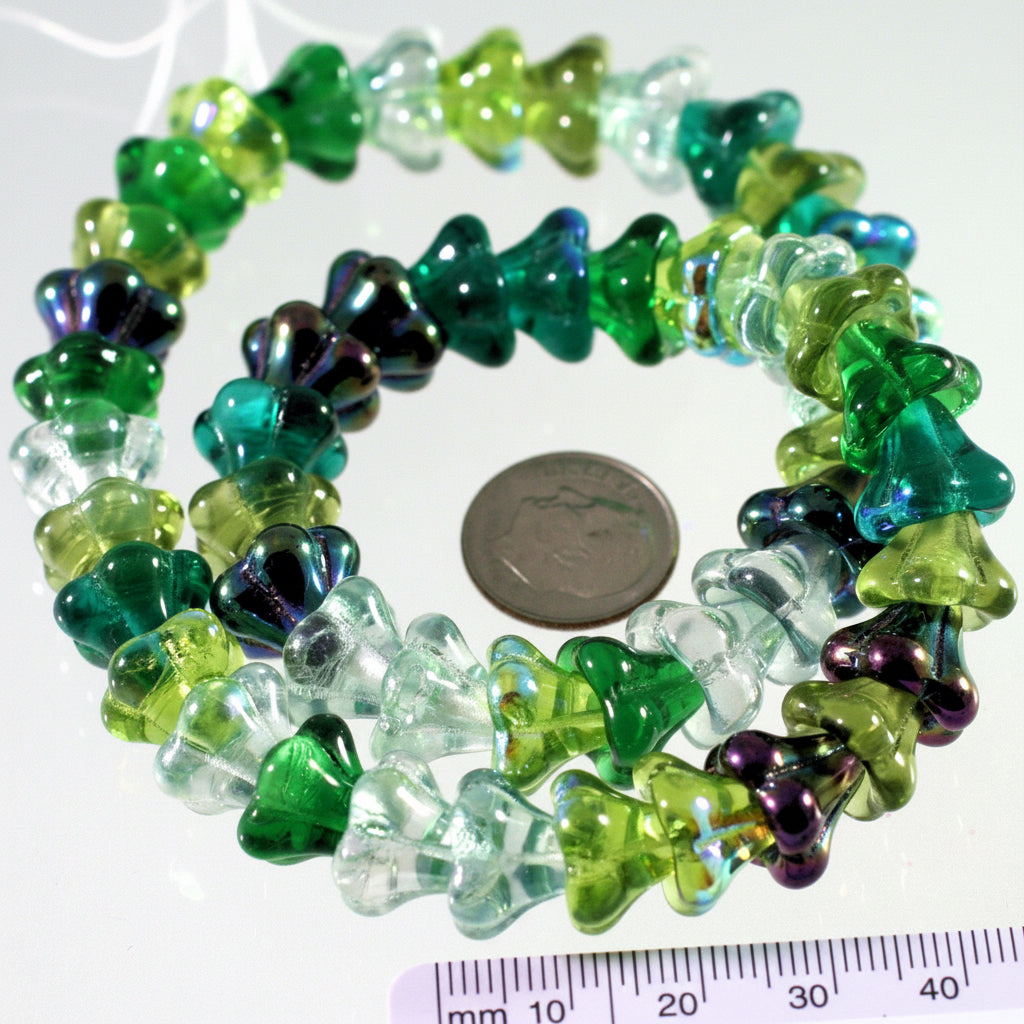 Colorful beads with a coin and ruler for size reference on a white background