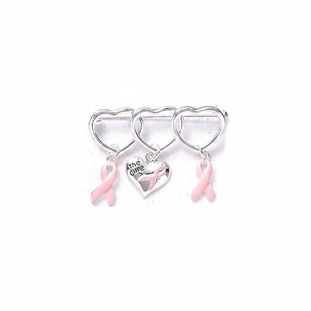 A silver-toned breast cancer awareness pin featuring three interlocking hearts, with two pink ribbon charms and a central heart engraved with 'the care' and a pink ribbon, shown on a plain white background.