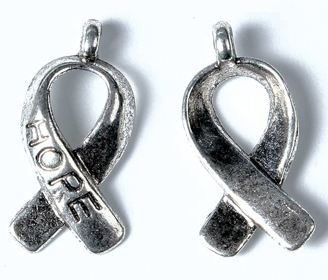 Two silver awareness ribbon pendants on a white background, one engraved with the word 'HOPE'.