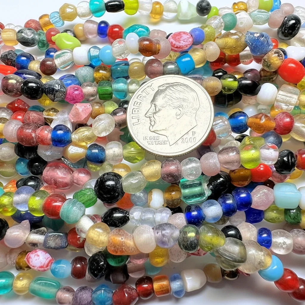 Multicolored beads with a coin for scale on a white background