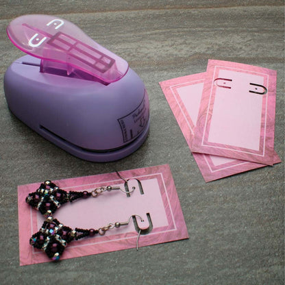 Purple paper punch with pink paper and earrings on a gray surface