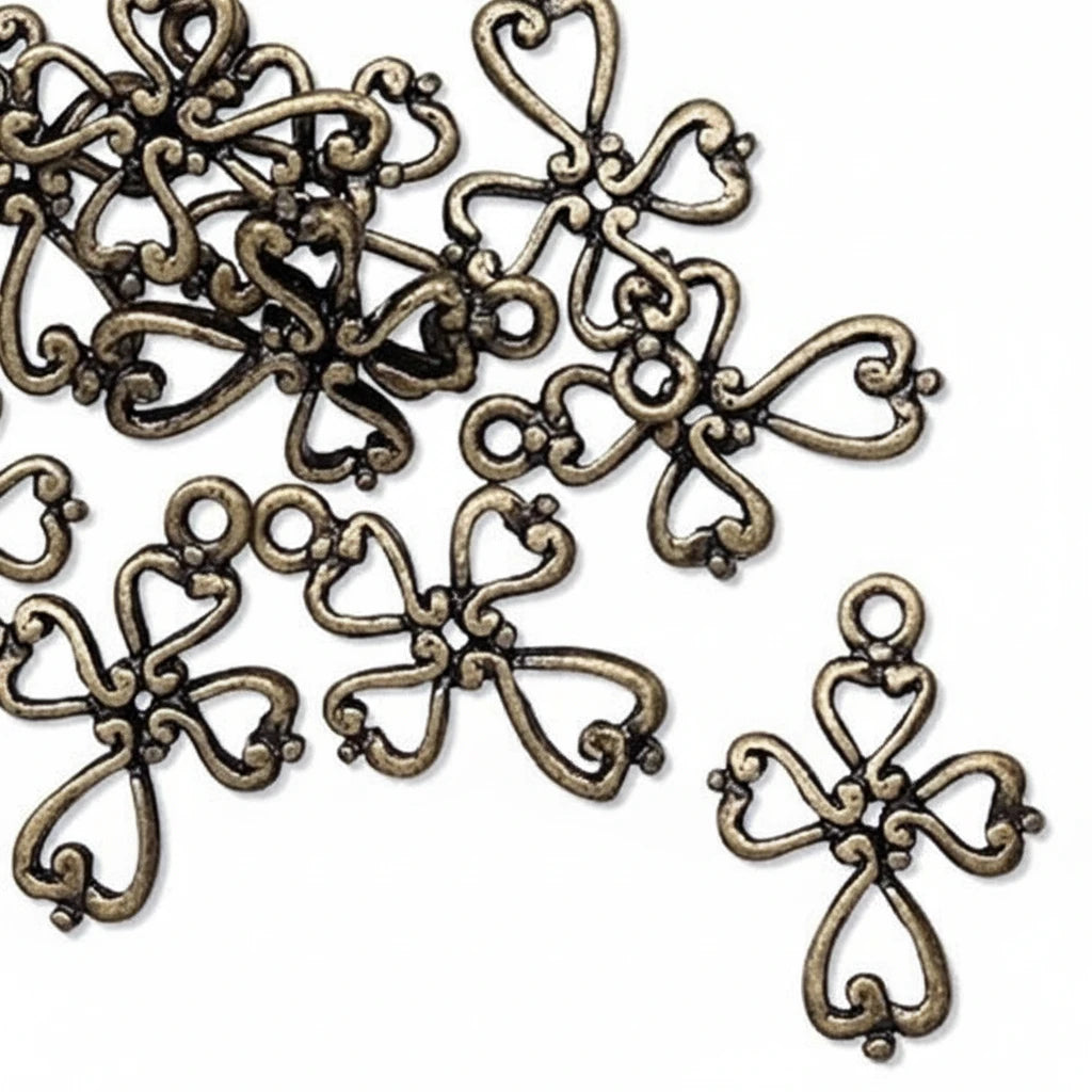 A pile of ornate metal jewelry findings with a heart motif and loop at the top, shown on a plain white background.