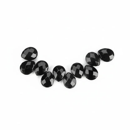 A row of faceted black oval gemstones arranged in a curved line on a plain white background.