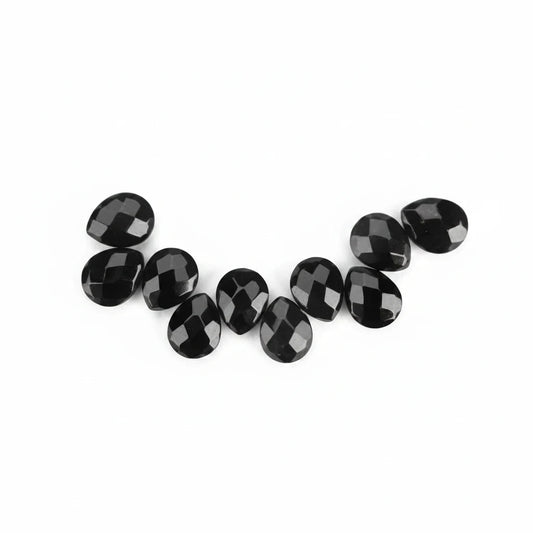 A row of faceted black oval gemstones arranged in a curved line on a plain white background.