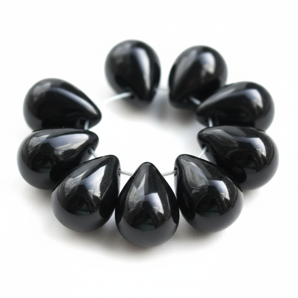 A bracelet made of glossy black teardrop-shaped beads strung on a thin silver wire, shown against a plain white background.