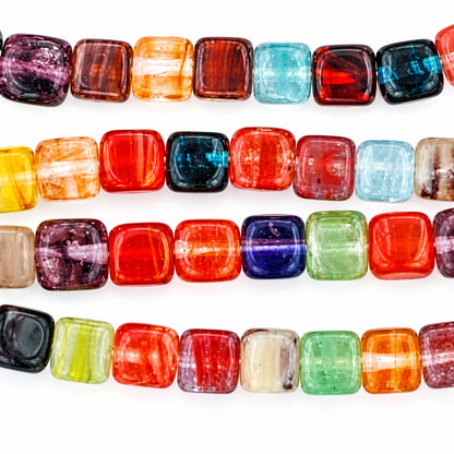Square glass beads in various colors, including red, orange, yellow, green, blue, purple, and black, arranged horizontally on a white background with the text 'The Mystical Garden Path' at the bottom.