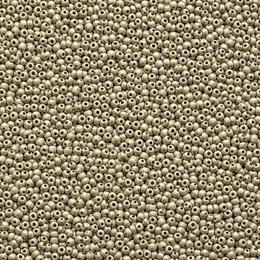 A close-up, top-down view of numerous small, round, off-white seed beads with central holes, densely packed together.