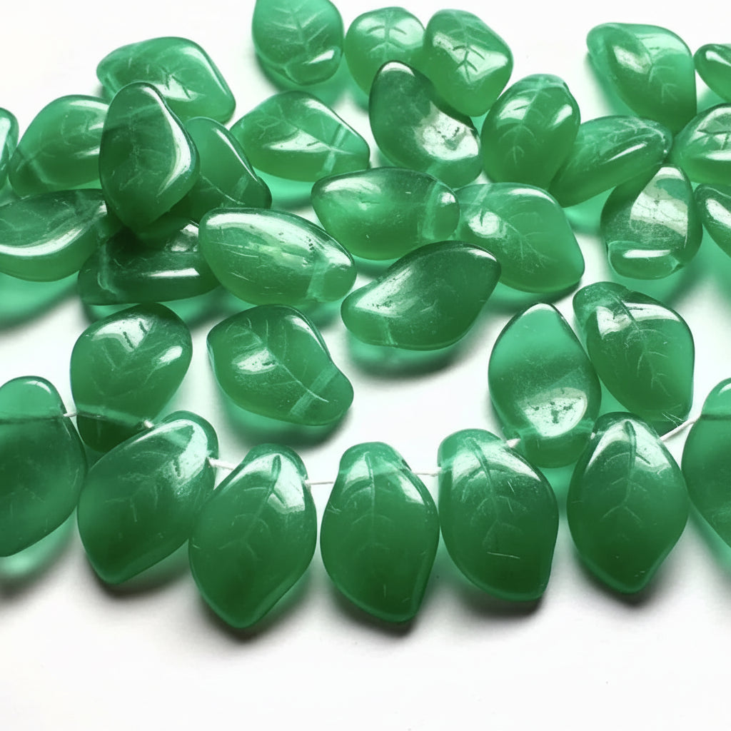 Green translucent stone beads with a smooth, polished finish and leaf-like organic shapes, arranged on a white background.