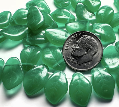 Green tumbled stone chips with a leaf shape, arranged in a circle around a silver dime for scale on a white background.