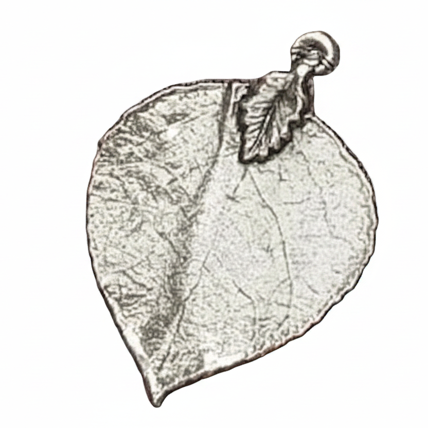 A leaf-shaped pendant or charm with a textured, metallic silver appearance and a small loop at the top. The word 'Mystical Garden Pa' is printed across the center on a plain white background.