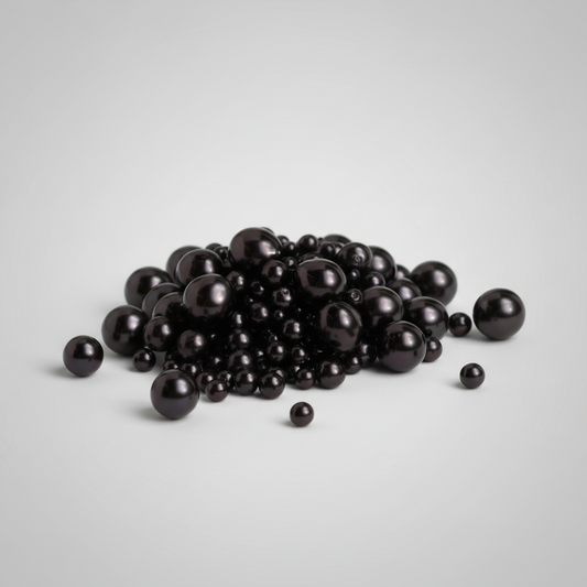 A pile of glossy black spherical beads in various sizes, arranged on a light gray gradient background.