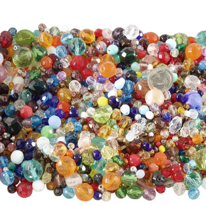 A dense pile of colorful faceted glass beads in many sizes and colors, including red, blue, green, yellow, orange, purple, pink, and clear beads, filling the frame.