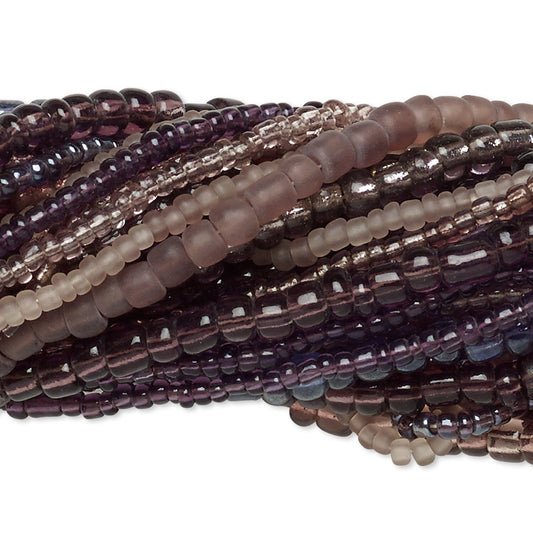 Multiple strands of faceted gemstone beads in shades of purple, smoky gray, and translucent brown, arranged in overlapping coils on a white background.
