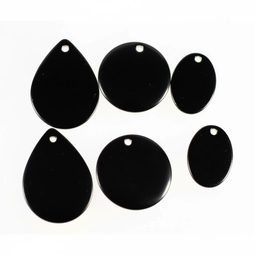 Six glossy black jewelry findings or charms with pre-drilled holes, including three teardrop-shaped pieces and three oval-shaped pieces, arranged on a plain white background.