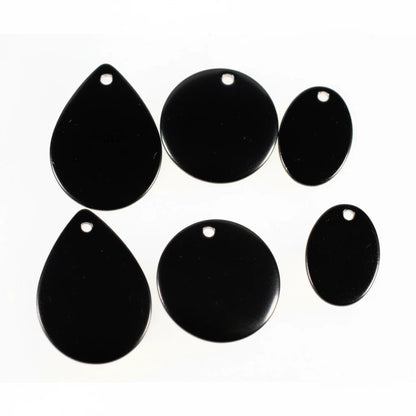 Six glossy black jewelry findings or charms with pre-drilled holes, including three teardrop-shaped pieces and three oval-shaped pieces, arranged on a plain white background.