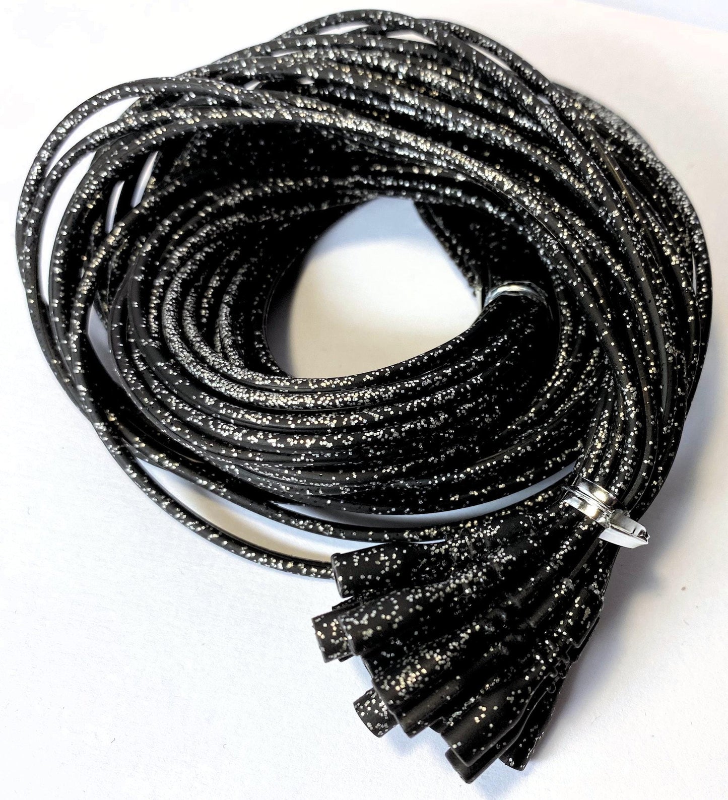 Coiled black glittery necklaces on a white background
