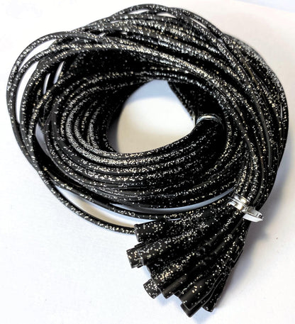 Coiled black glittery necklaces on a white background