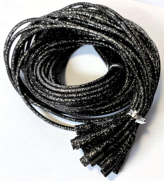 Coiled black glittery necklaces on a white background