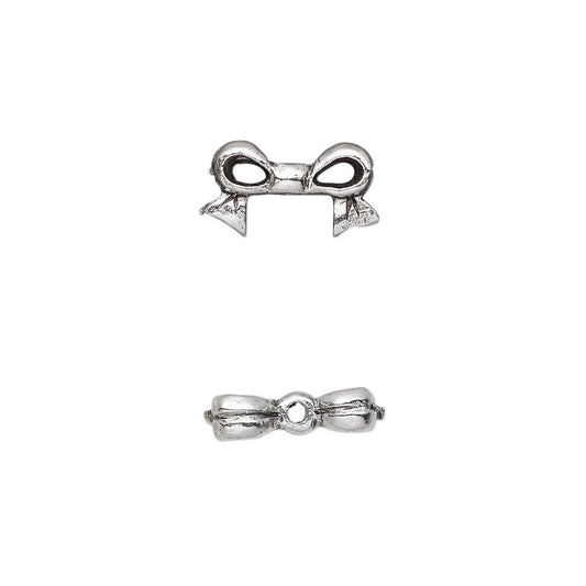 A pair of silver-toned metal bow charms shown from two angles (top and side views) on a plain white background.