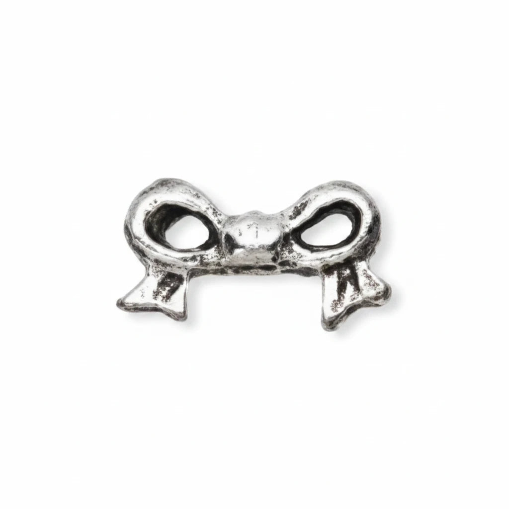 A small silver metal charm shaped like a bow, shown on a plain white background with a dashed vertical line indicating orientation.