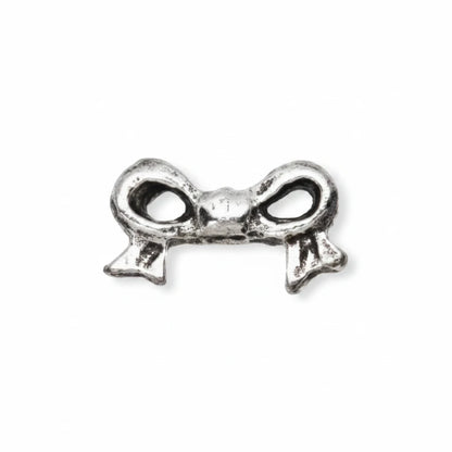 A small silver metal charm shaped like a bow, shown on a plain white background with a dashed vertical line indicating orientation.