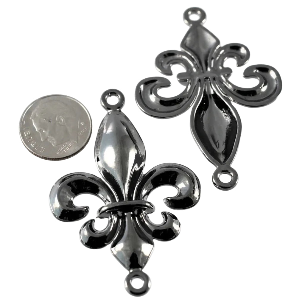 Two shiny silver fleur-de-lis jewelry charms shown on a white background, with a U.S.