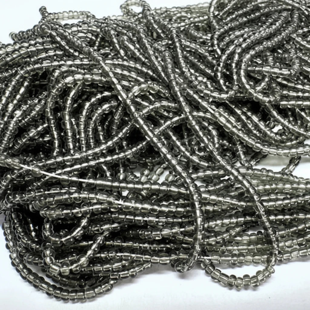 A pile of metallic silver seed beads wound together on a plain white background.